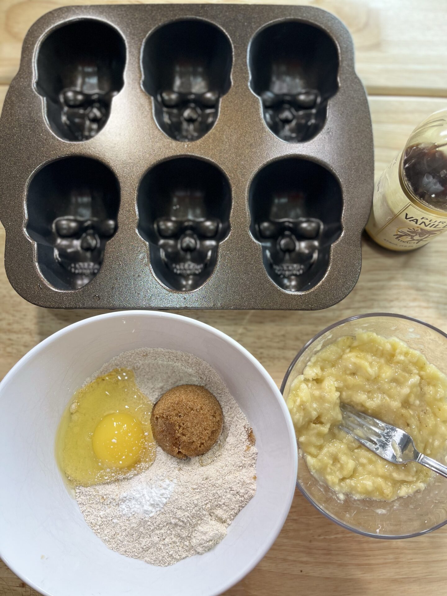 bowl with oat flour, brown sugar, and egg next to a skull baking mold 