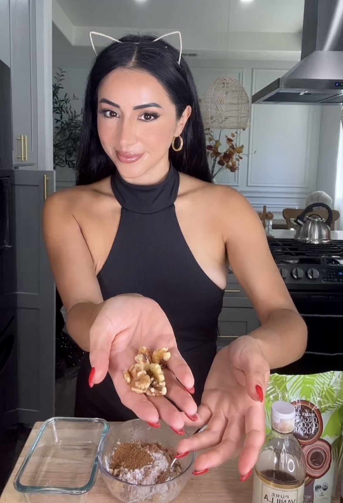 woman wearing cat ears holding walnuts in her hand making chocolate brownies