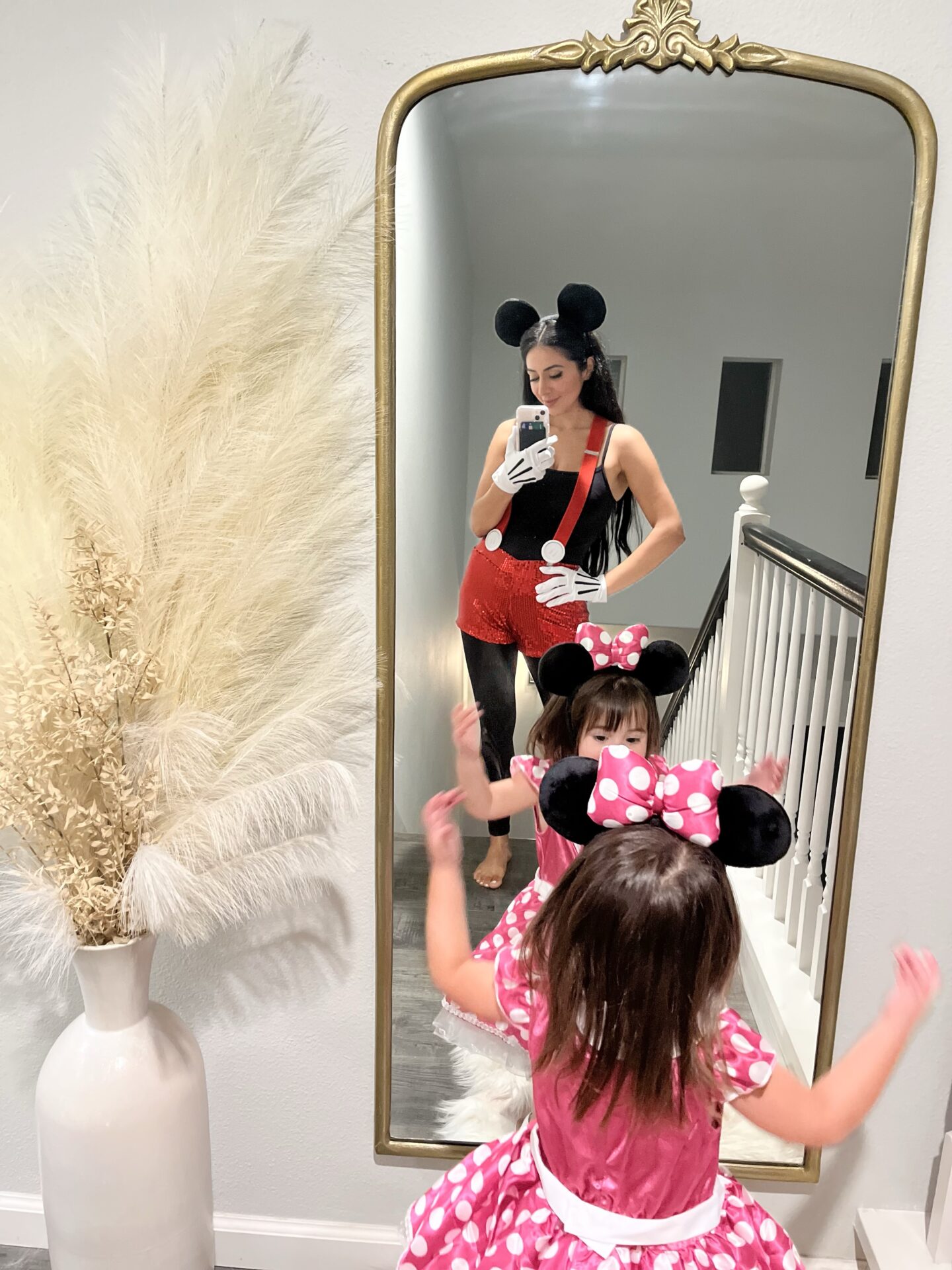 woman wearing mickey mouse adult costume and toddler wearing a minnie mouse costume
