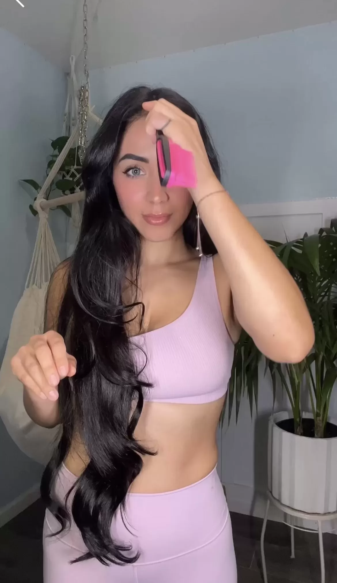 woman parting her long dark hair with a tangle teezer comb