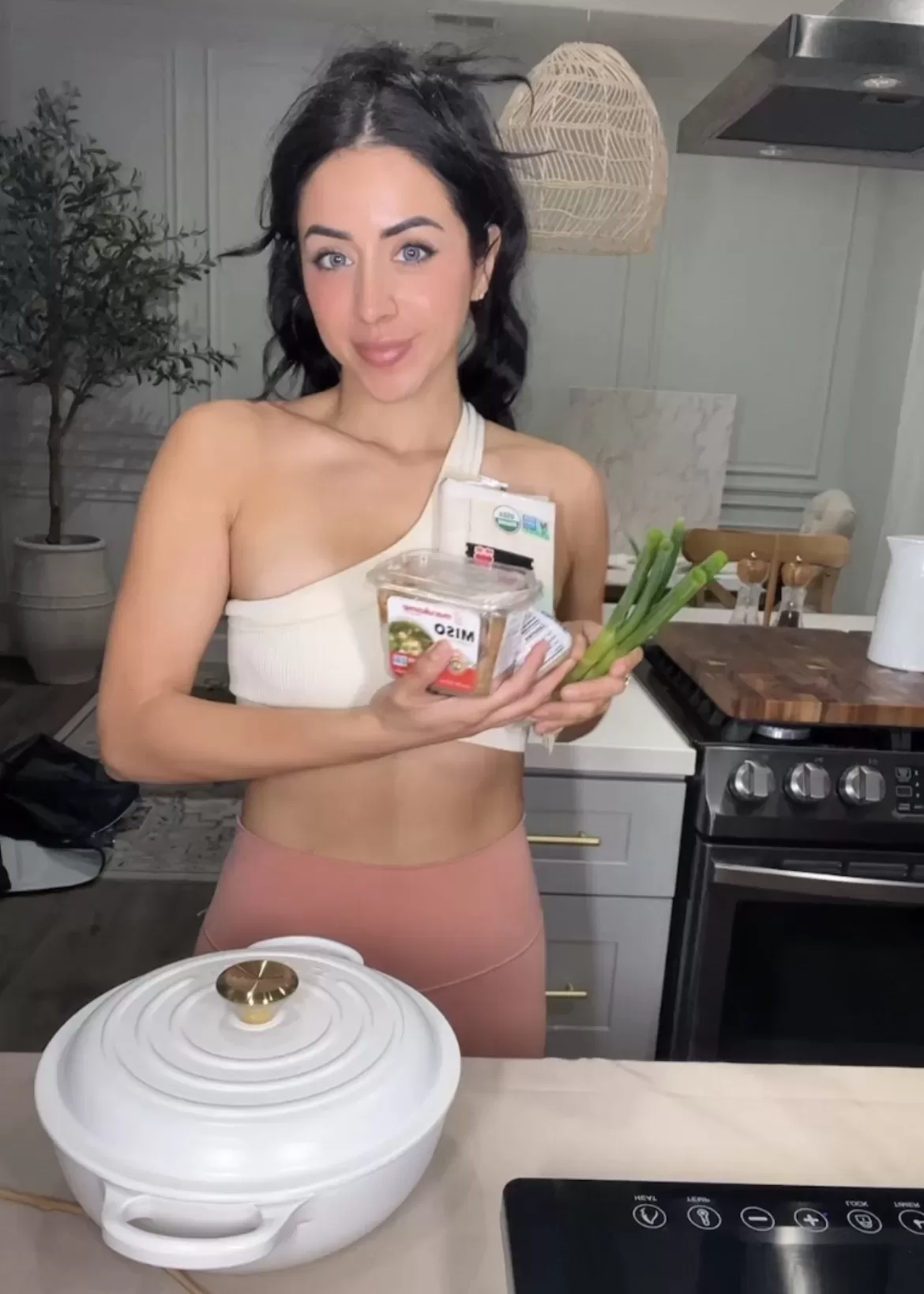 fit woman holding miso soup ingredients